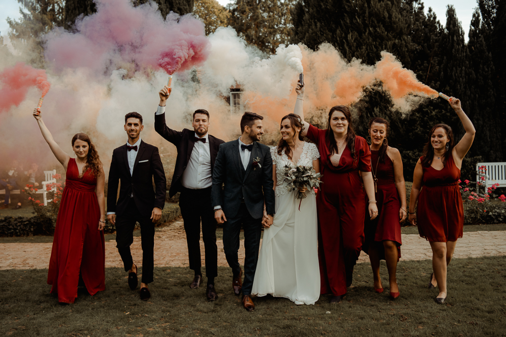 Photo de mariage des mariés et de leurs témoins avec des fumigènes 